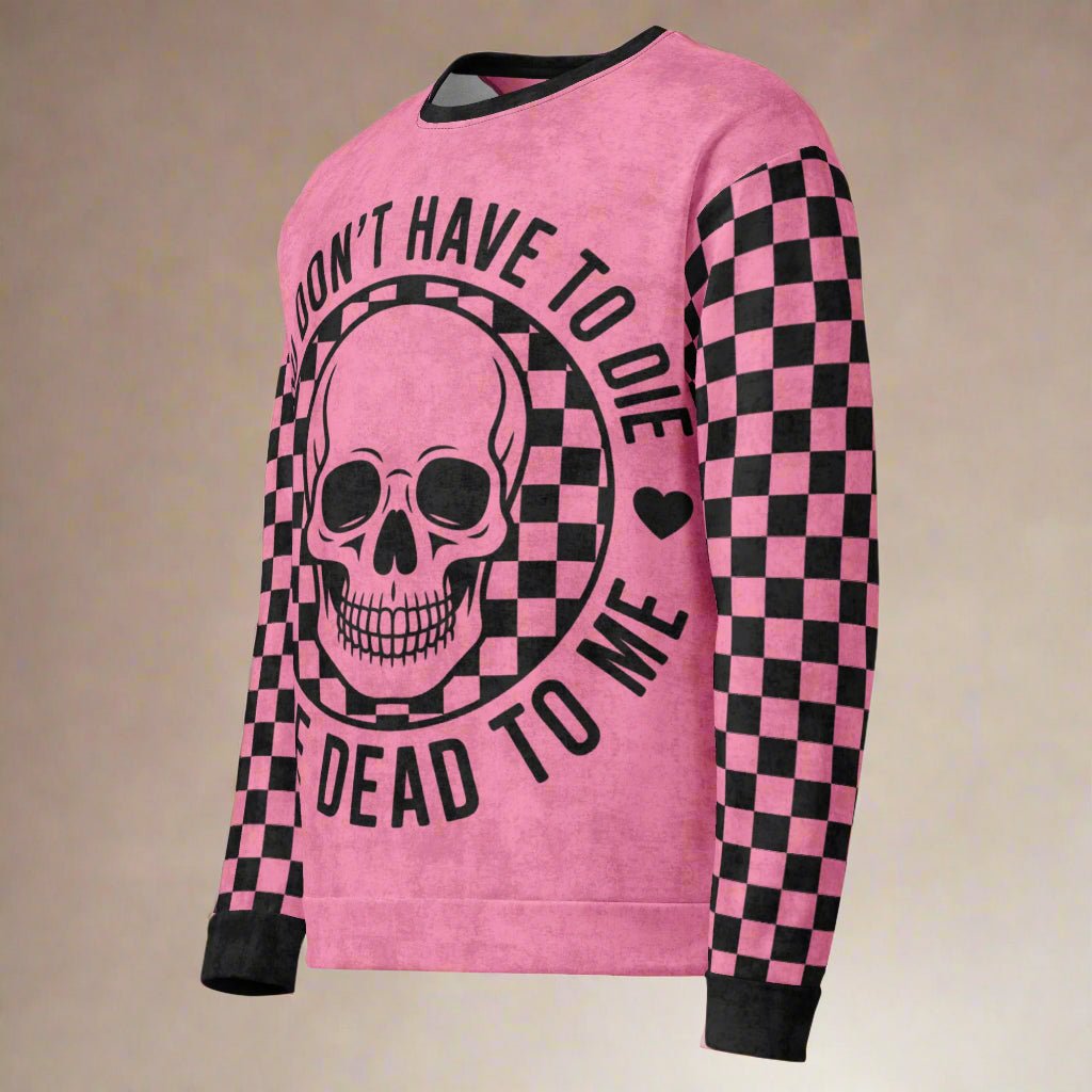 Pink sweater with skull design and text on a beige background