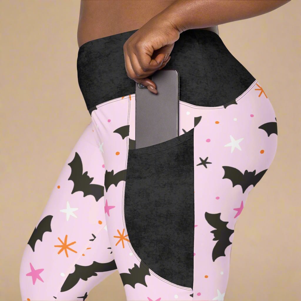 Pink leggings with black bat patterns on a white background