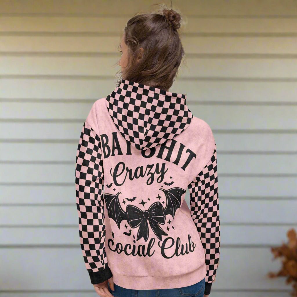 Pink hoodie with black checkered sleeves and text on a white background