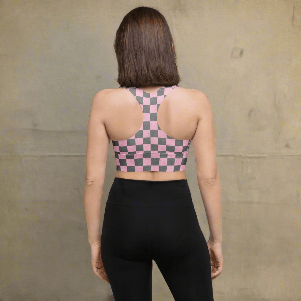 Person wearing a checkered sports bra and black leggings on a neutral background