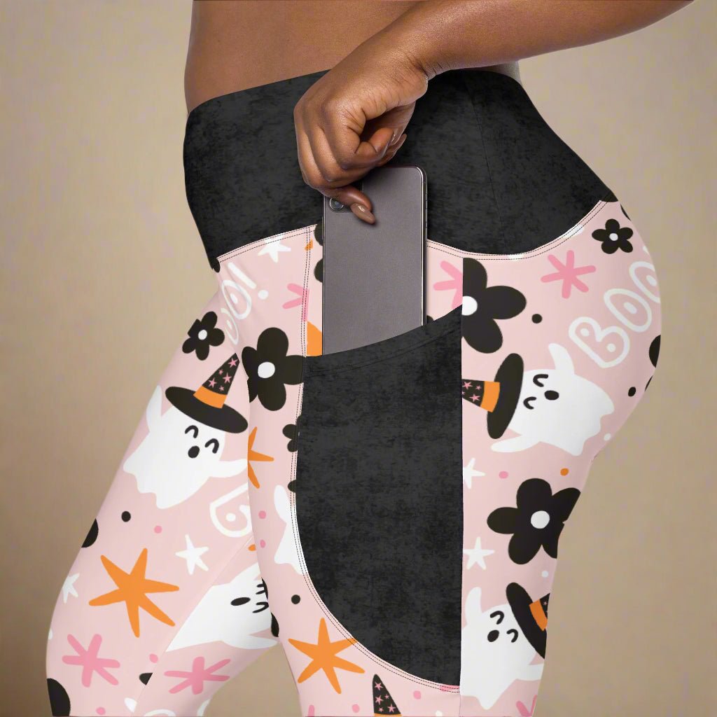 Leggings with Halloween-themed design featuring ghosts, pumpkins, and stars on a pink background.
