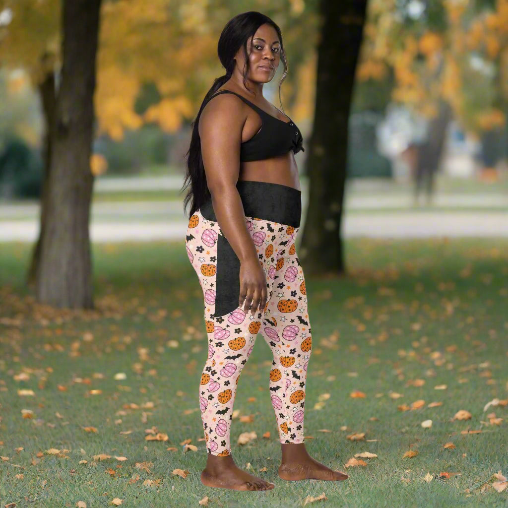 Woman wearing black sports bra and halloween leggings on a white background