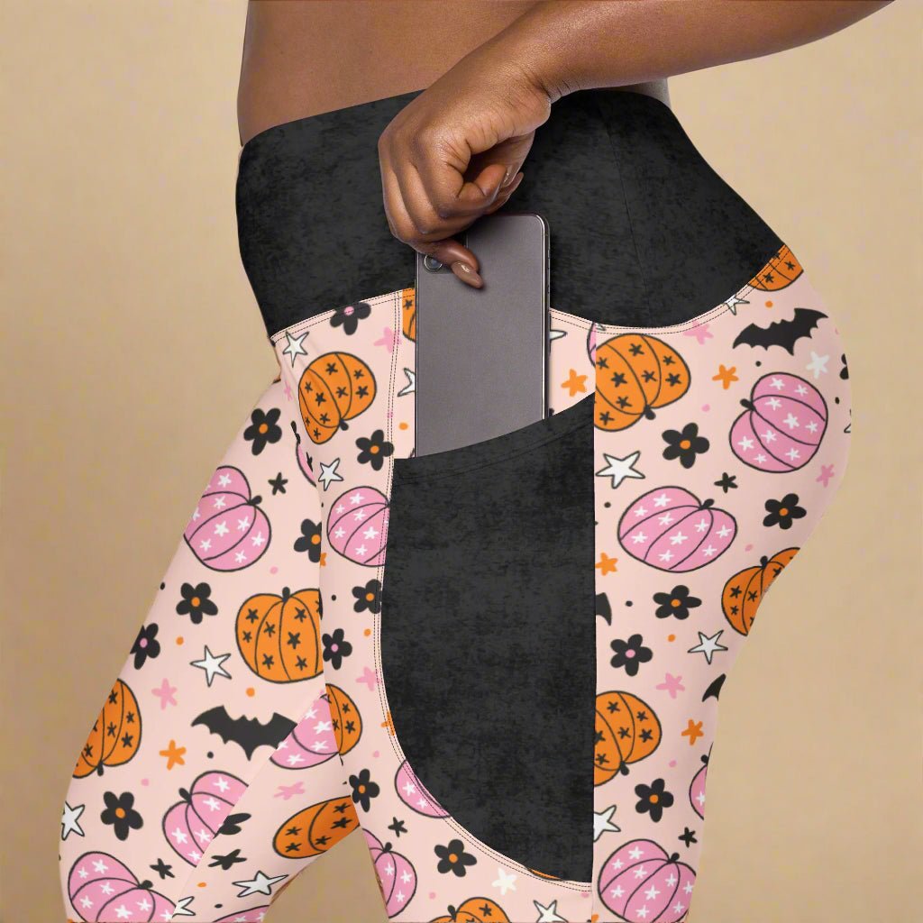 Leggings with Halloween pattern featuring pumpkins, bats, and stars on a beige background.