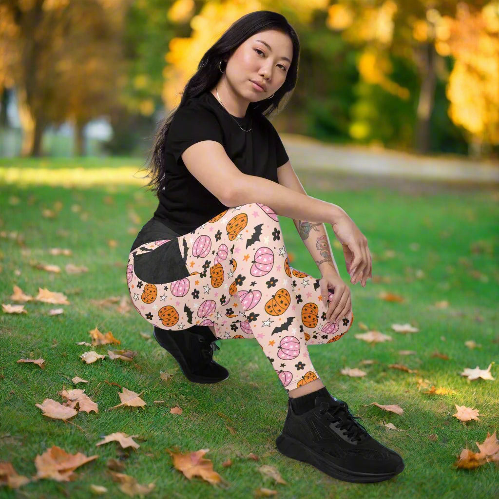 Person wearing a black t-shirt and halloween leggings sitting on the floor.