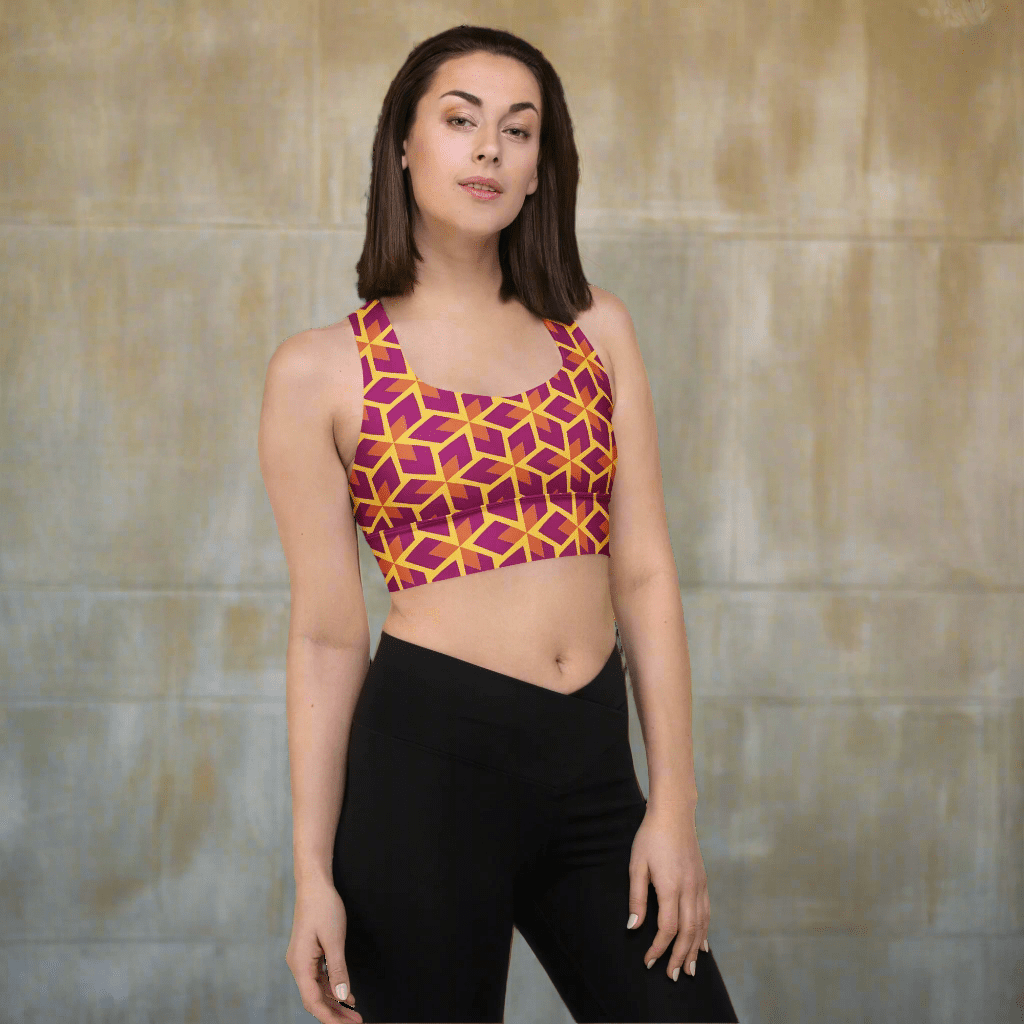 Woman wearing a colorful geometric-patterned sports bra and black leggings on a beige background
