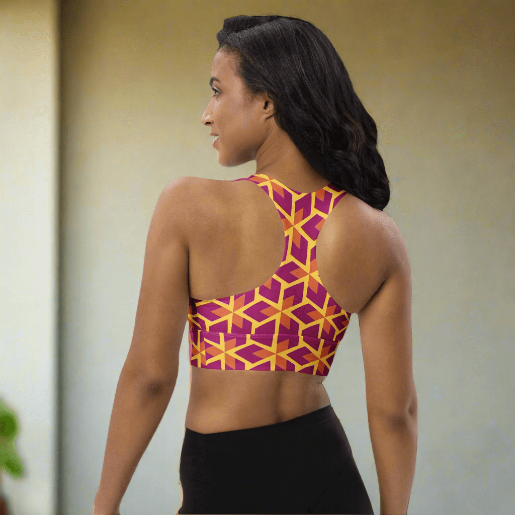 Woman wearing a colorful geometric-patterned sports bra on a white background