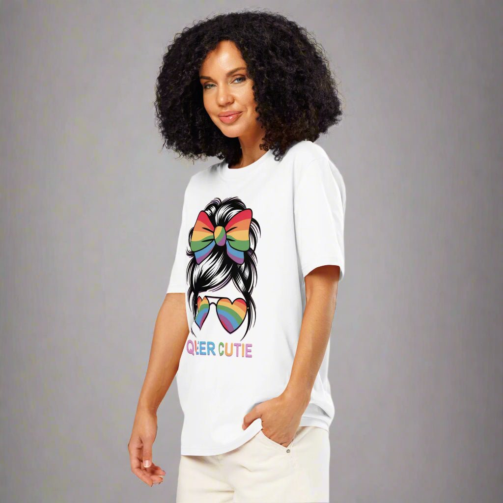 Person wearing a white t-shirt with rainbow hair and 'QUEER CUTIE' text design.
