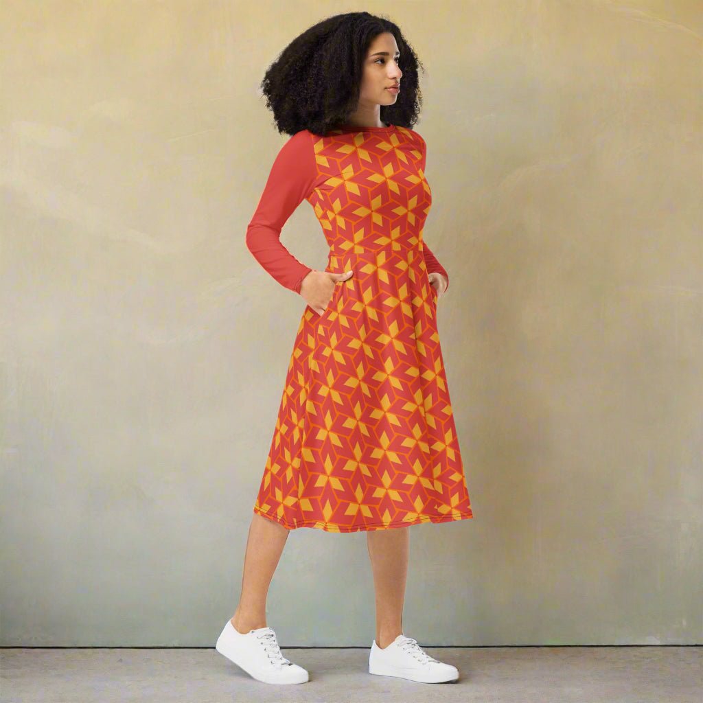 Woman wearing a red and yellow patterned dress on a neutral background