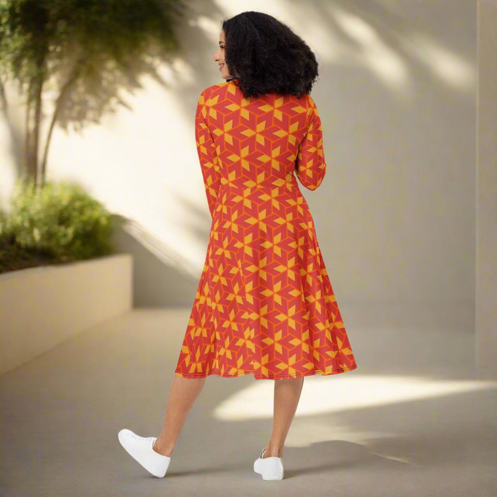 Woman wearing a red and yellow patterned dress on a neutral background