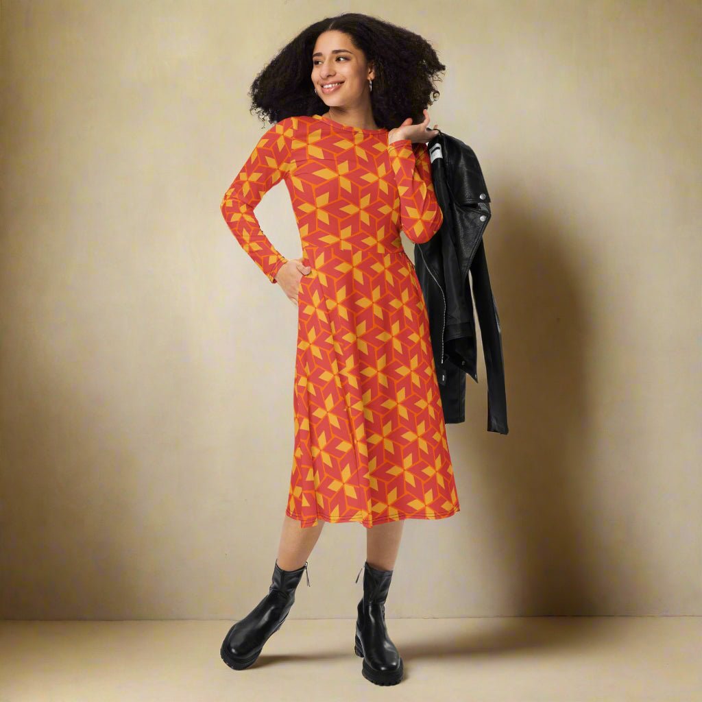 Woman wearing a red and yellow patterned dress with a black jacket on a neutral background