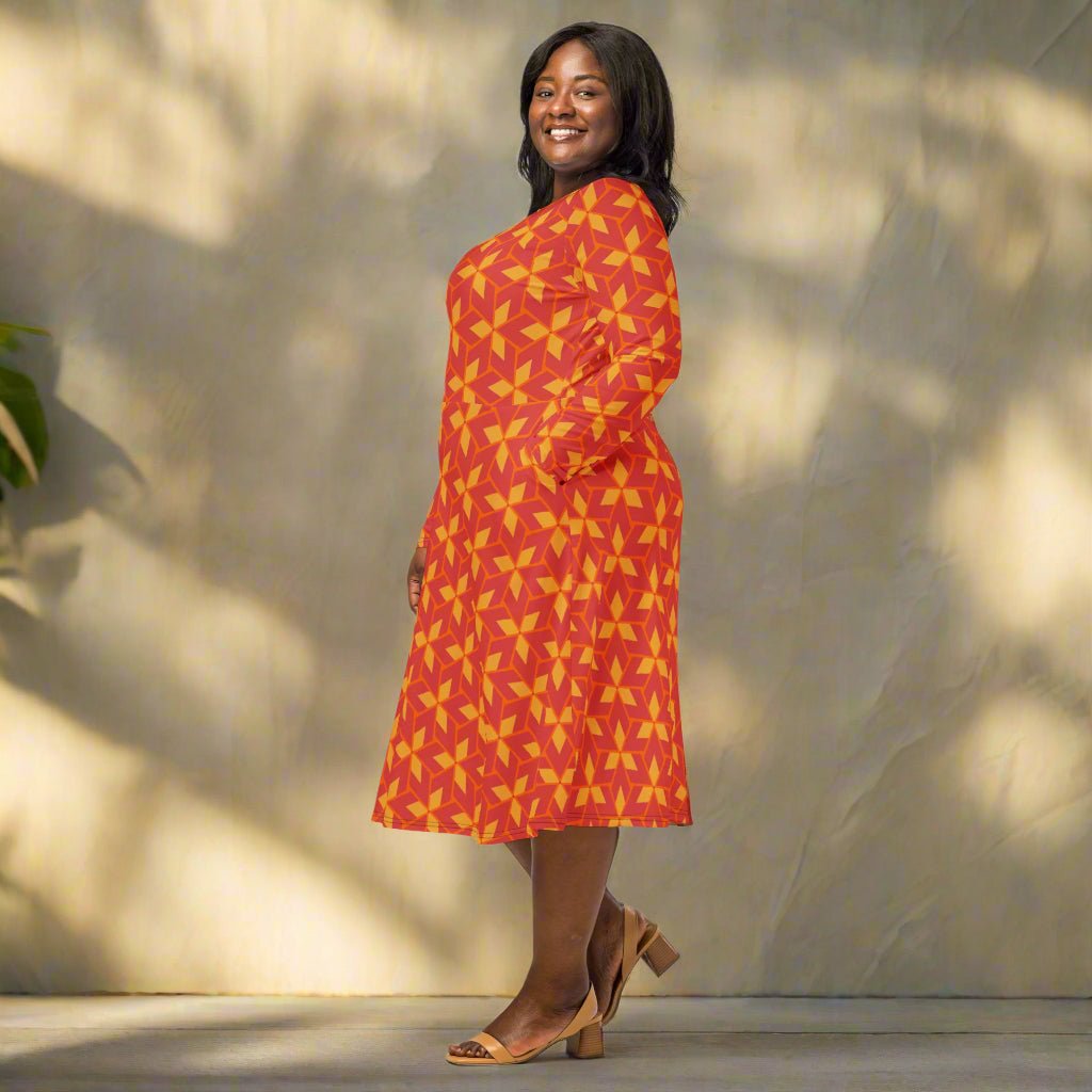 Woman wearing a red and yellow patterned dress standing outdoors with a neutral background