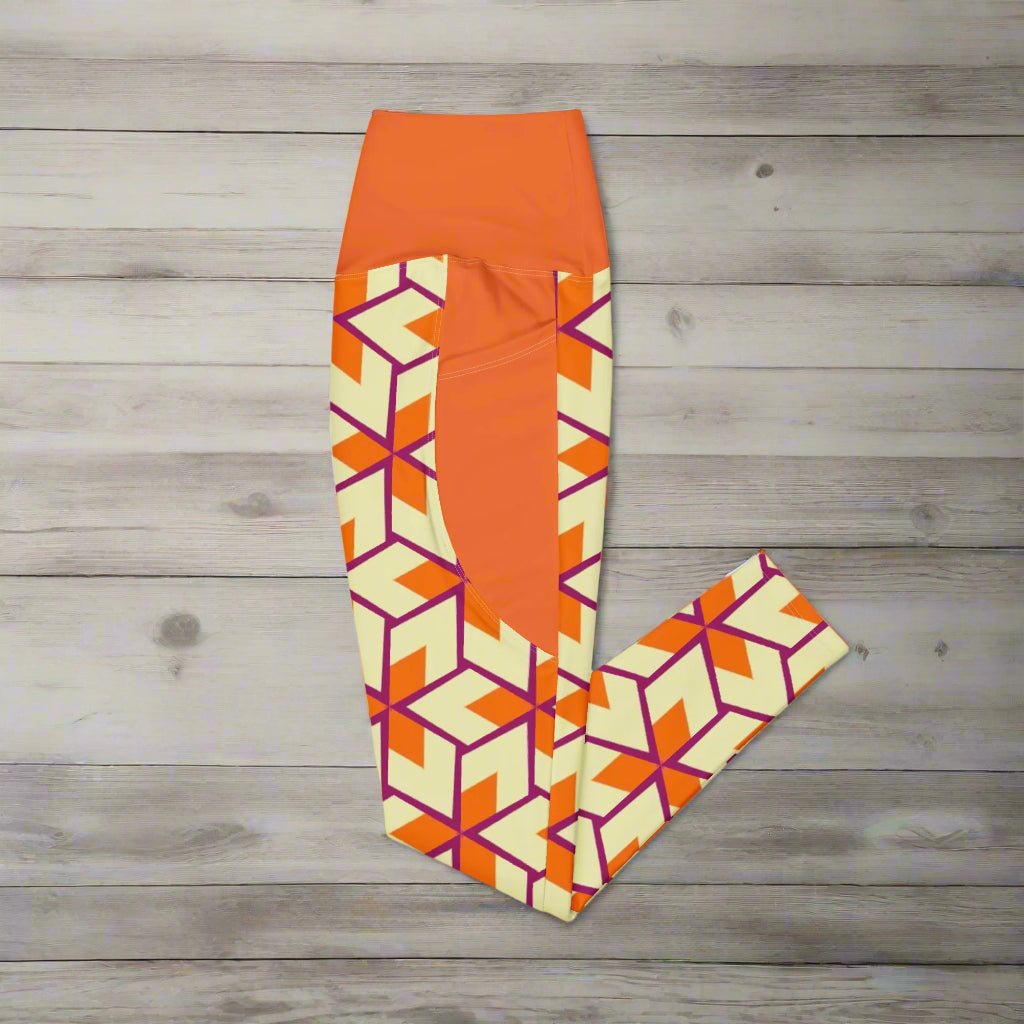 Orange Retro Geometric High-Waisted UPF 50+ Pocket Leggings 2XS–6XL | Dopamine Dressing Recycled Yoga Pants | Moisture Wicking Compression, folded and laying on a wooden surface
