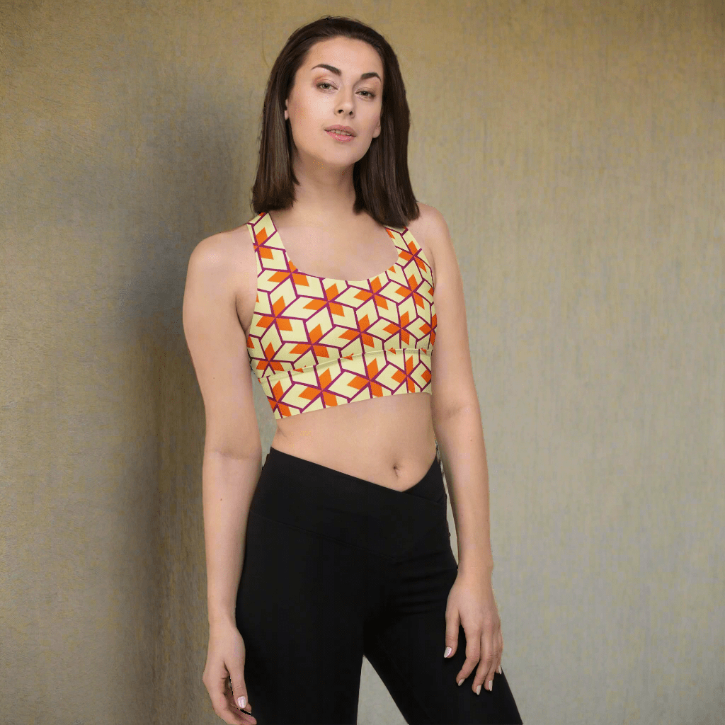 Woman wearing a colorful geometric-patterned crop top on a neutral background