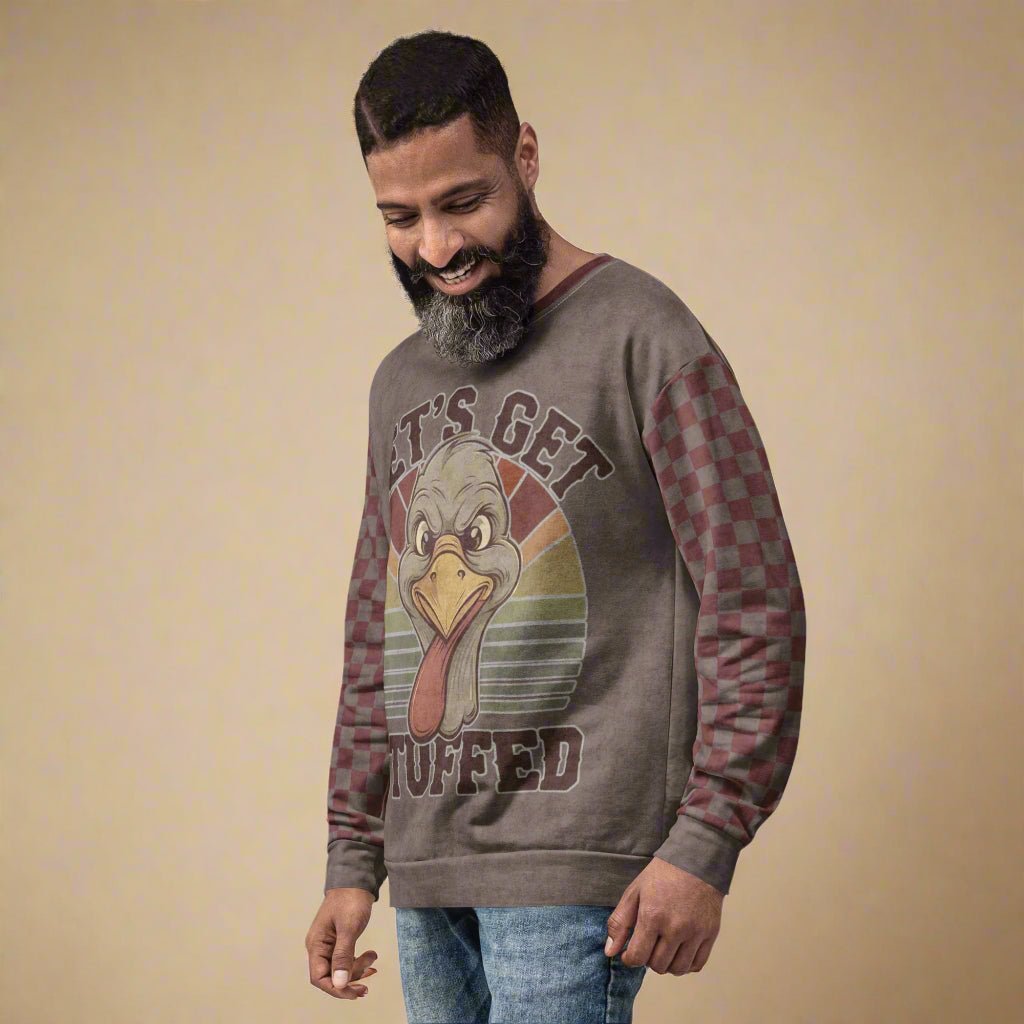Man wearing a gray sweatshirt with a graphic design on a beige background