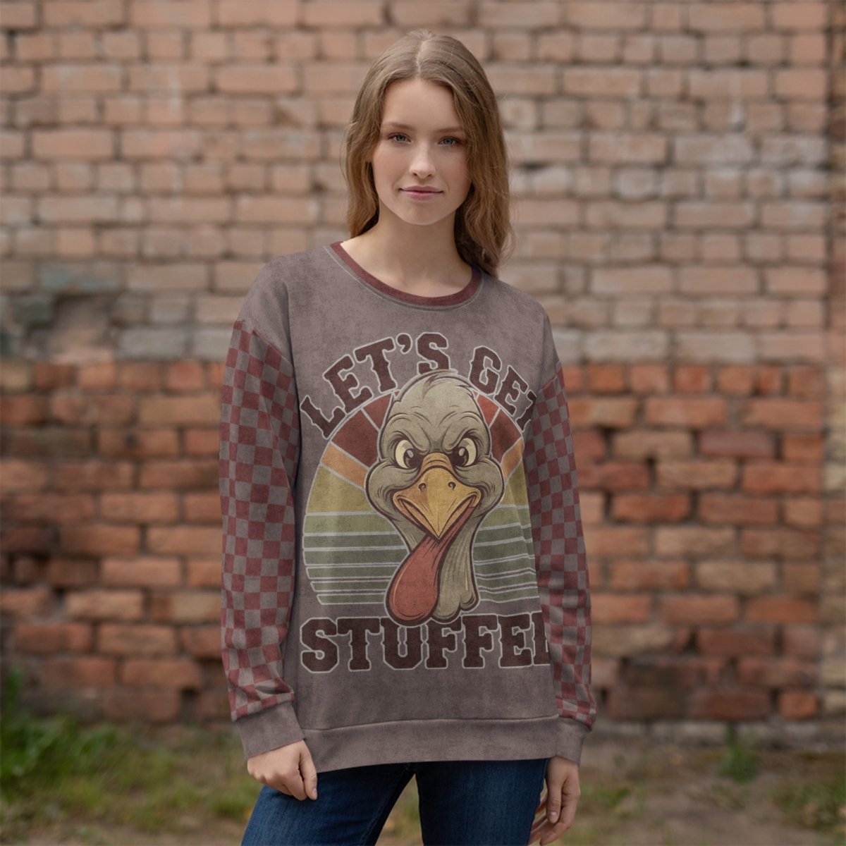 Person wearing a sweater with a turkey graphic and 'Let's Get Stuffed' text against a brick wall.