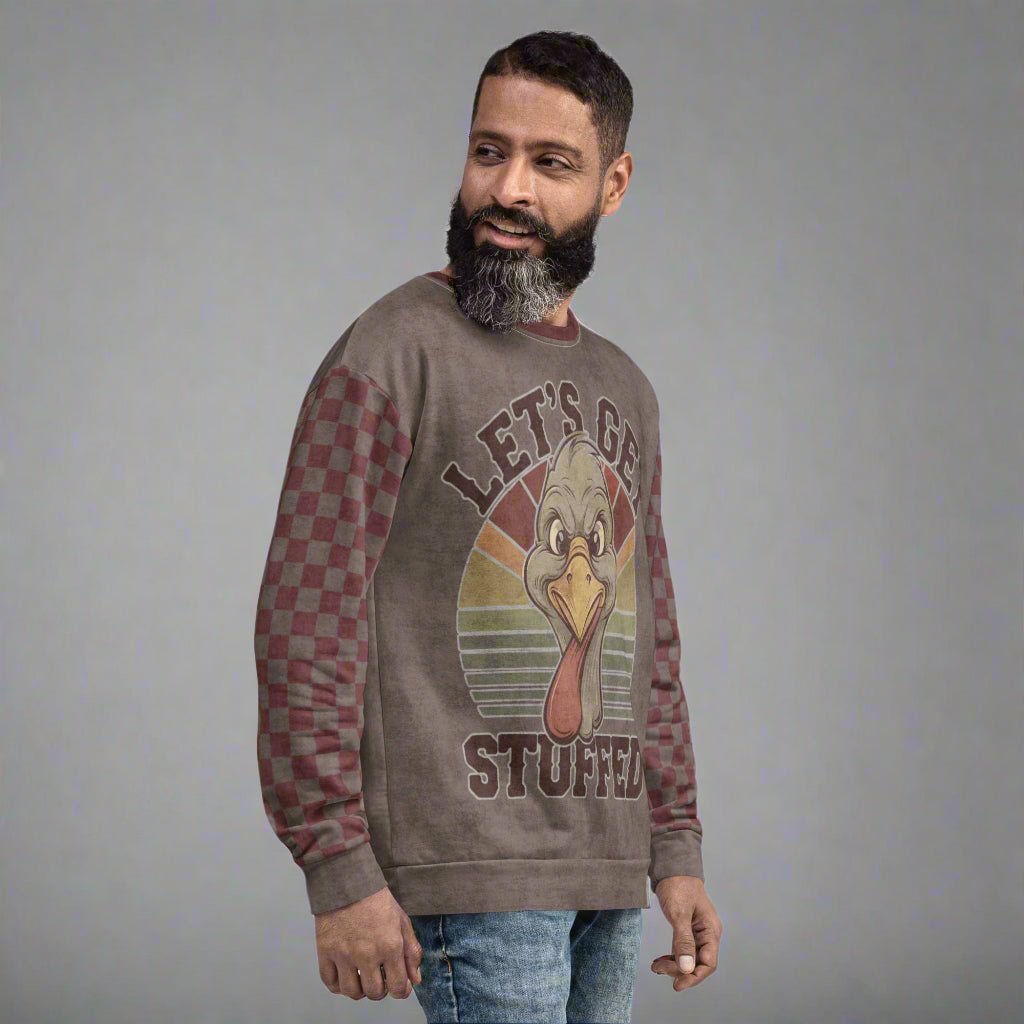 Man wearing a sweater with a graphic design of a turkey and text 'Let's Get Stuffed' on a neutral background