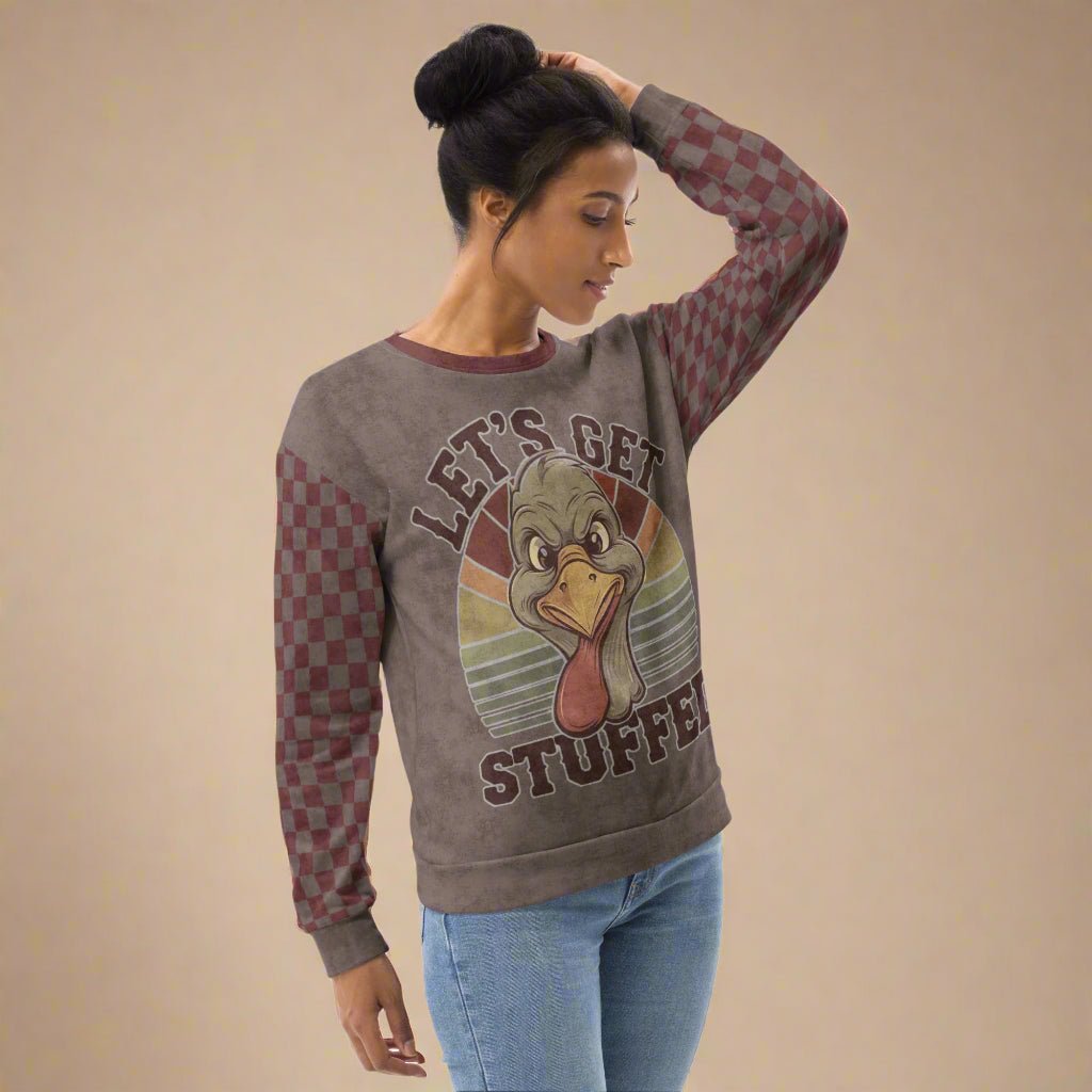 Woman wearing a sweater with a turkey and "Let's Get Stuffed" on a neutral background
