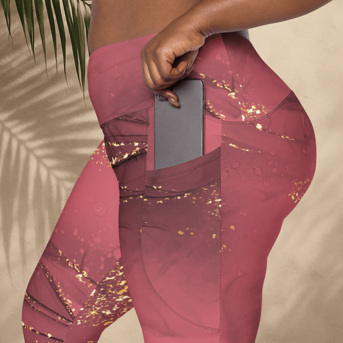 dusty rose leggings with gold glitter pattern worn by a person, holding a phone.
