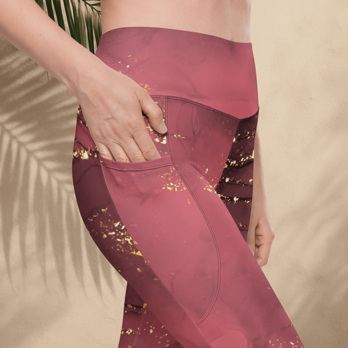 dusty rose leggings with gold glitter pattern worn by a person against a beige background