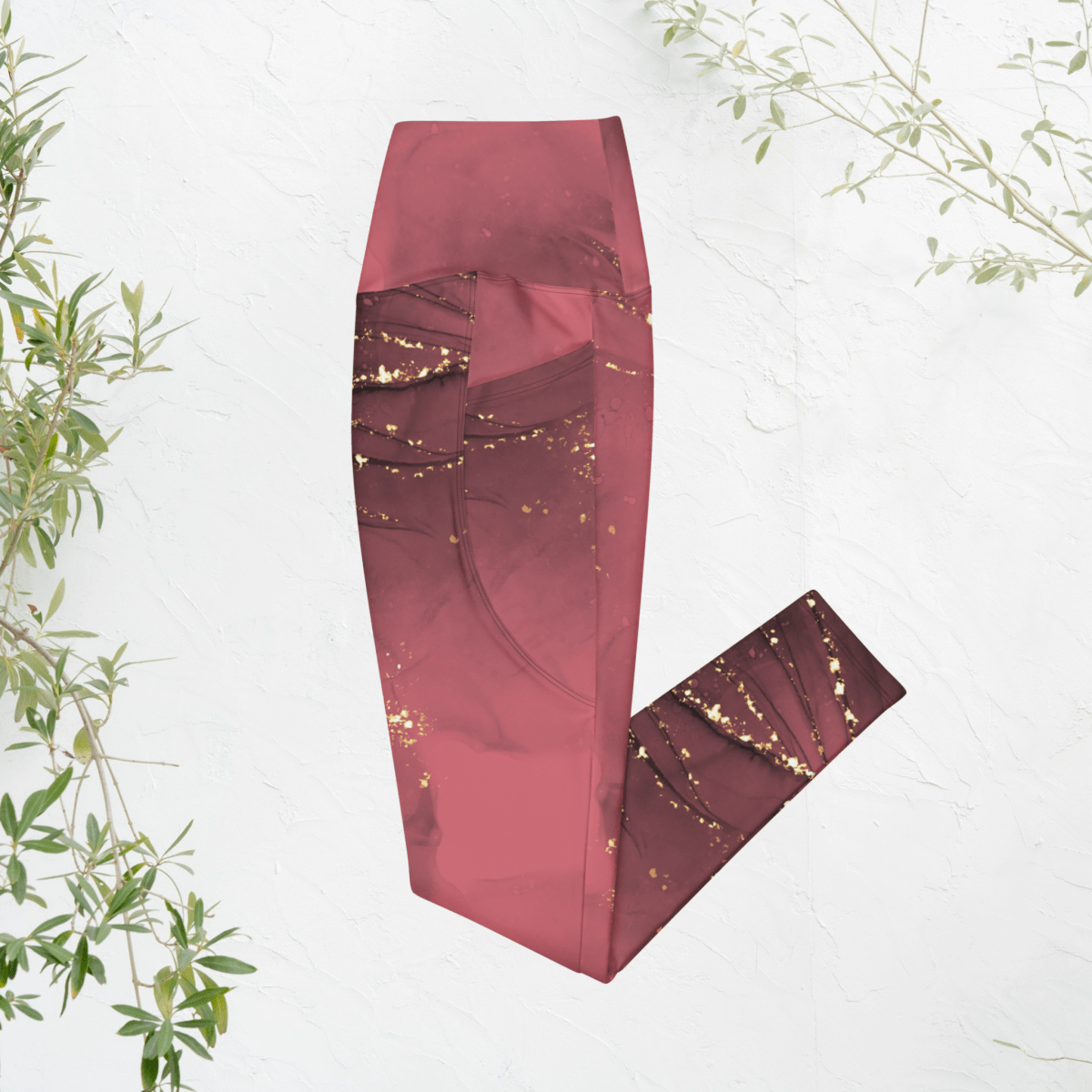 dusty rose leggings with gold speckles on a white background with green leaves.