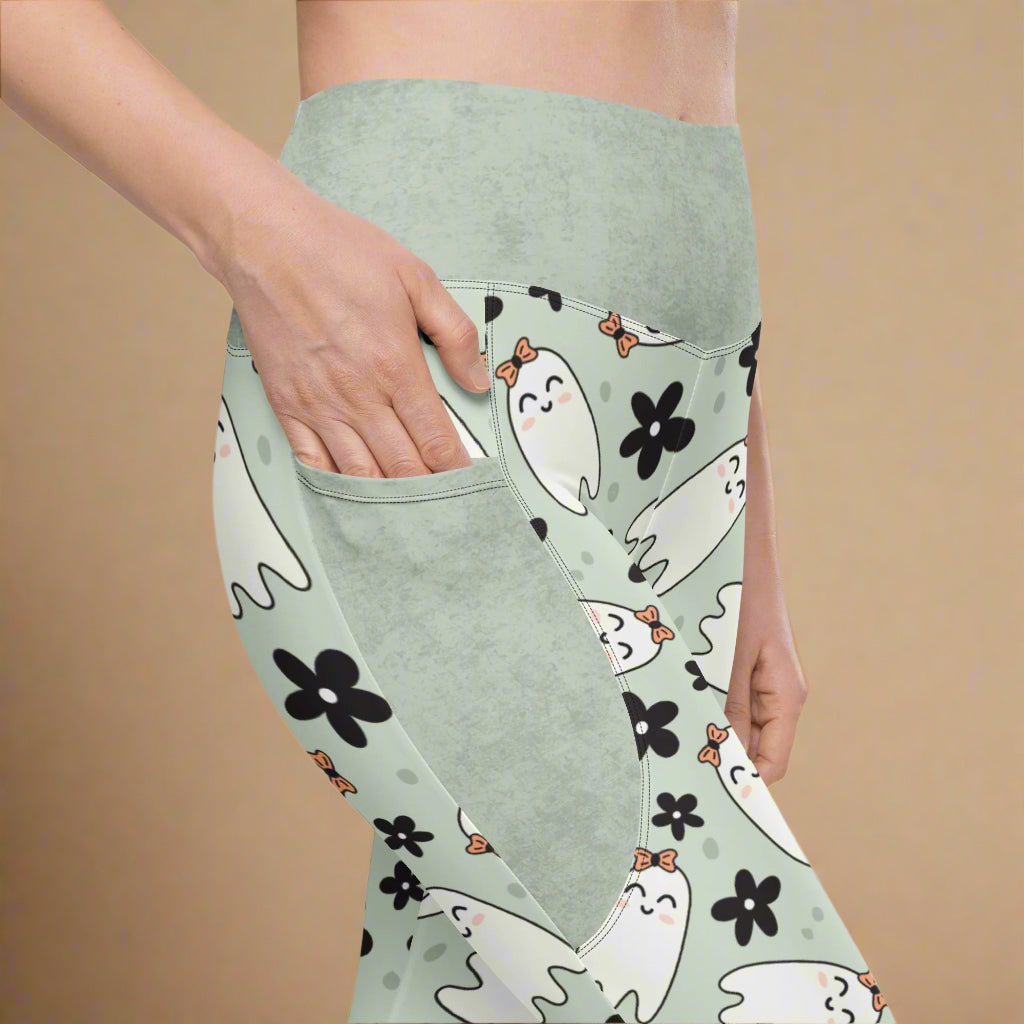 Light sage leggings with ghost and flower pattern on a beige background