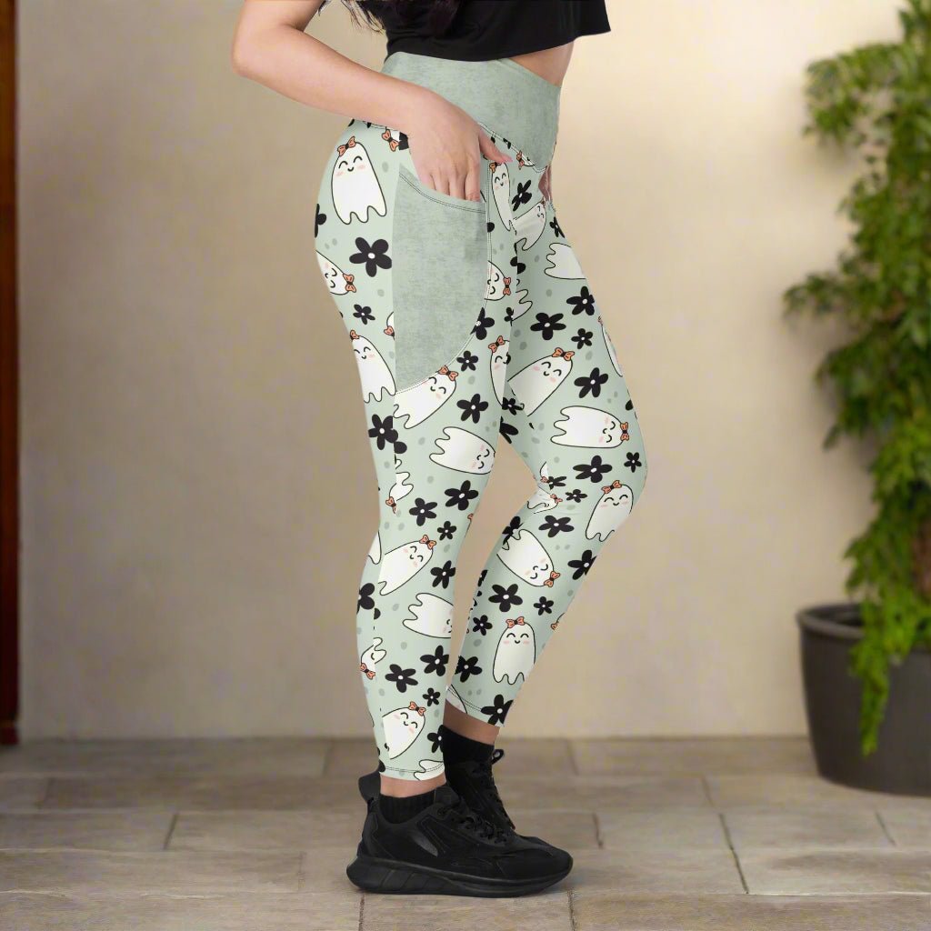 Person wearing light green leggings with cartoon ghost and flower pattern indoors.