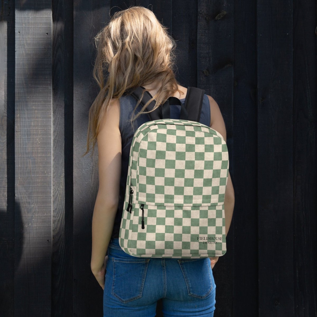 Person wearing a green and white checkered backpack against a dark background