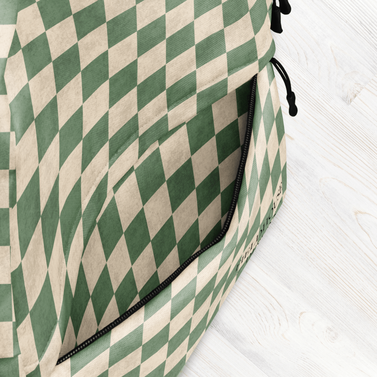 Green and beige checkered bag on a white wooden surface