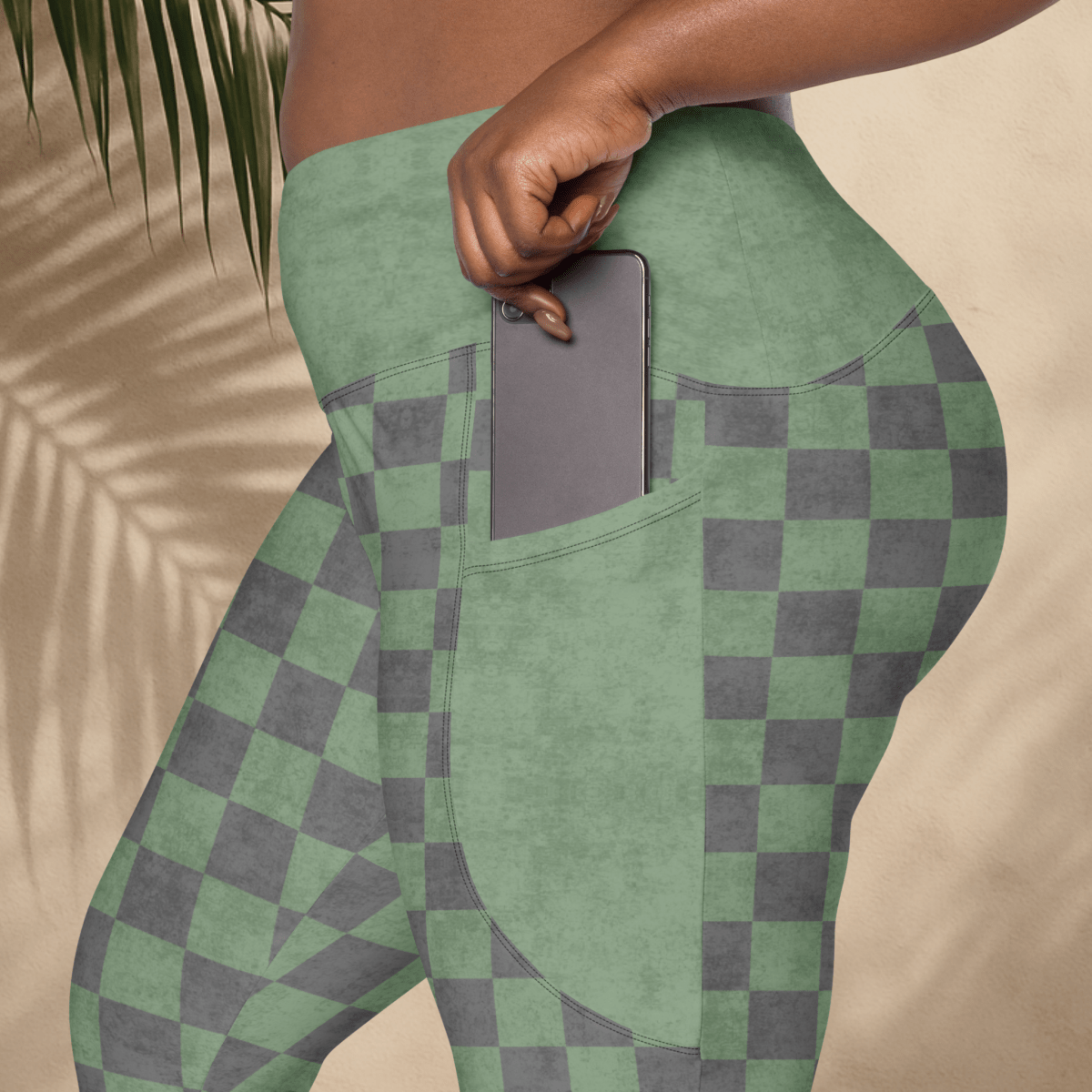 Green and gray checkered leggings with a pocket on a beige background