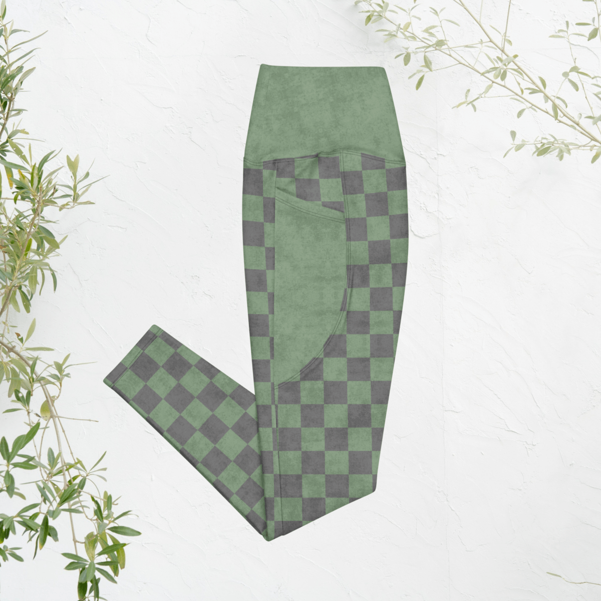 Green and gray checkered leggings on a white background with plant elements.