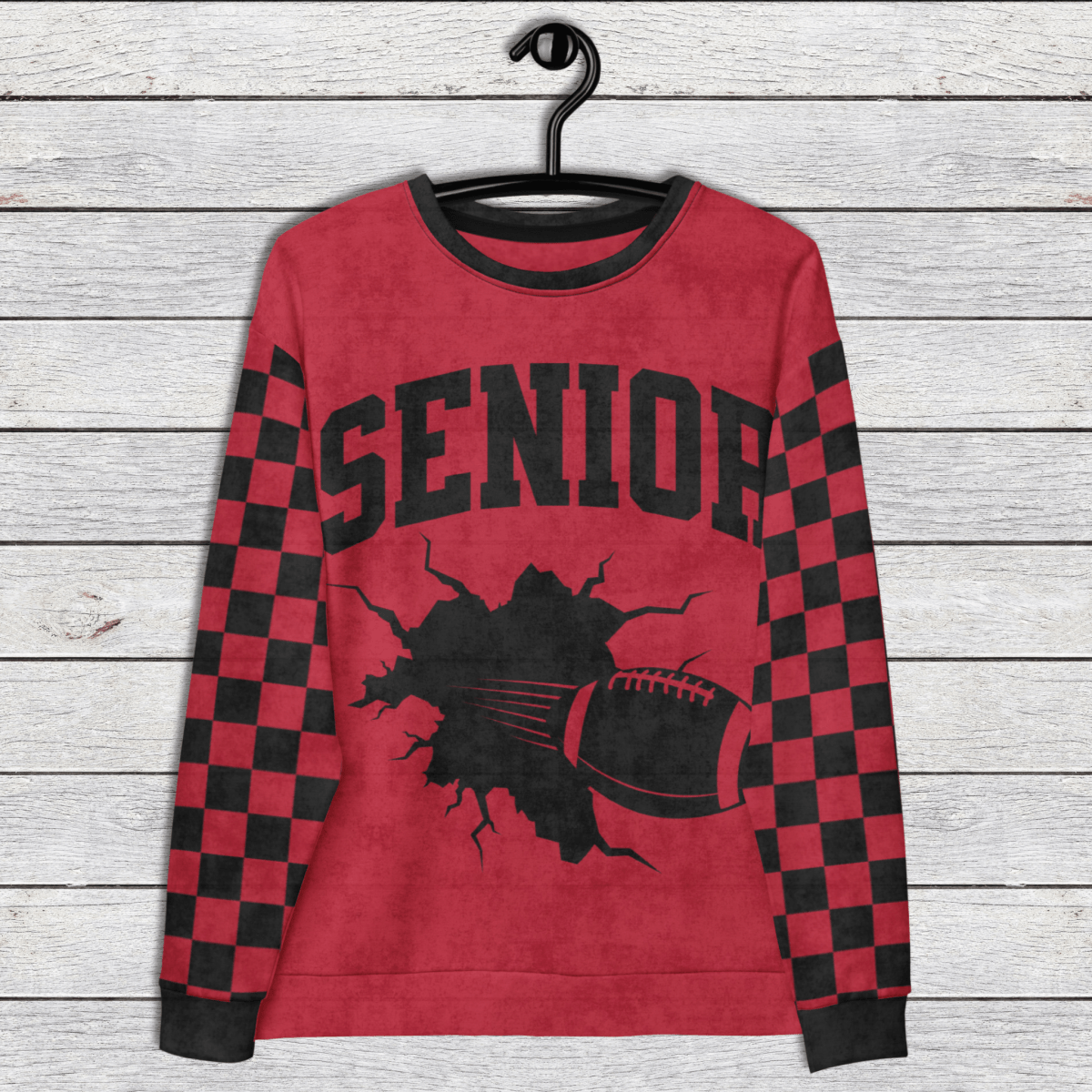 Red sweatshirt with 'Senior' and football graphic on a wooden background