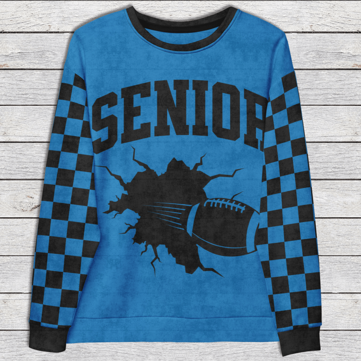 Blue sweatshirt with 'Senior' text and football graphic on a wooden surface