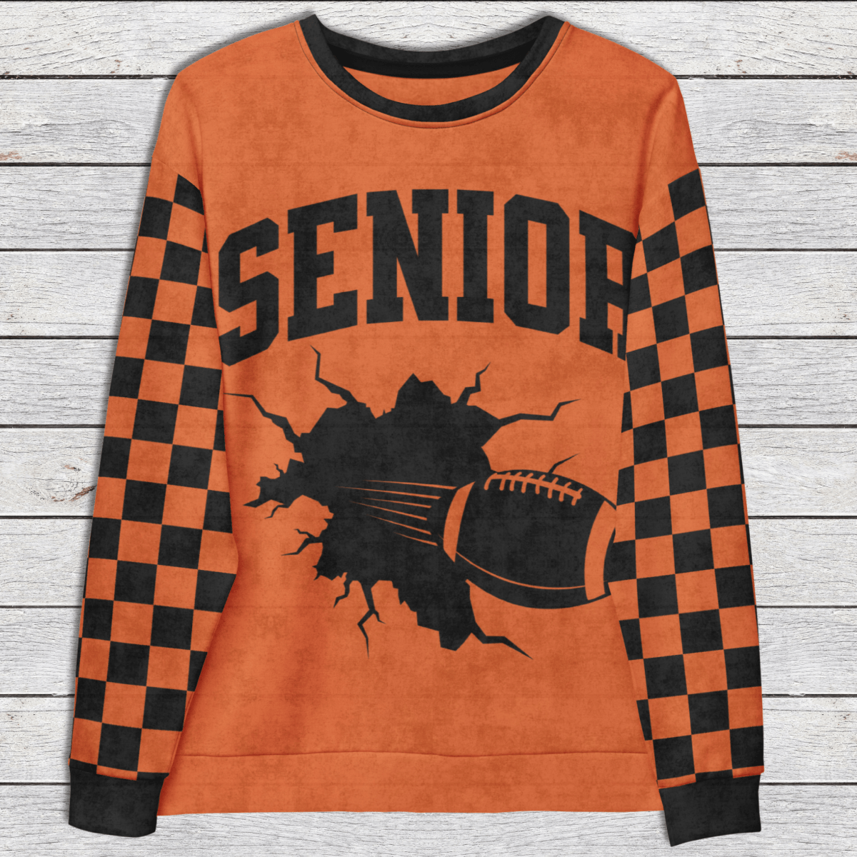 Orange sweatshirt with 'SENIOR' and football graphic on a wooden surface