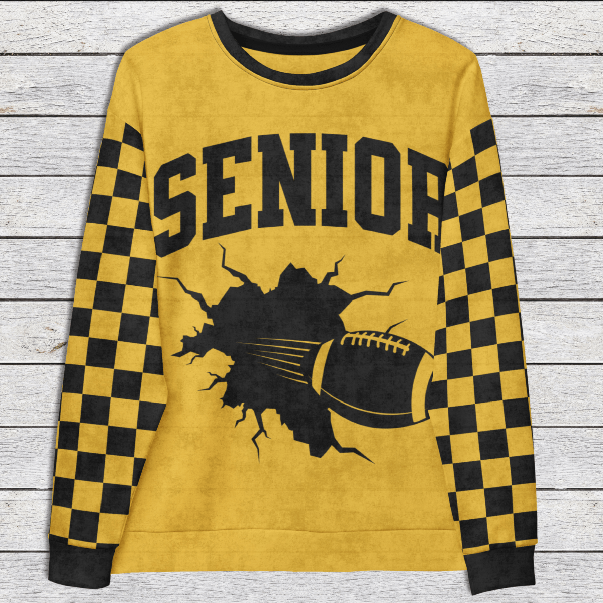 Yellow sweatshirt with 'SENIOR' text and football graphic on a wooden surface