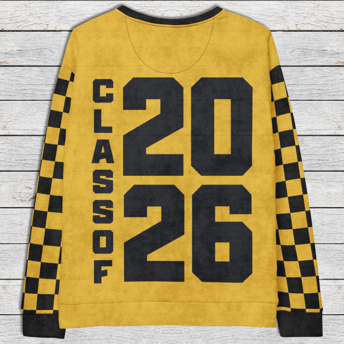 Yellow sweatshirt with 'Class of 2026' text on a wooden surface
