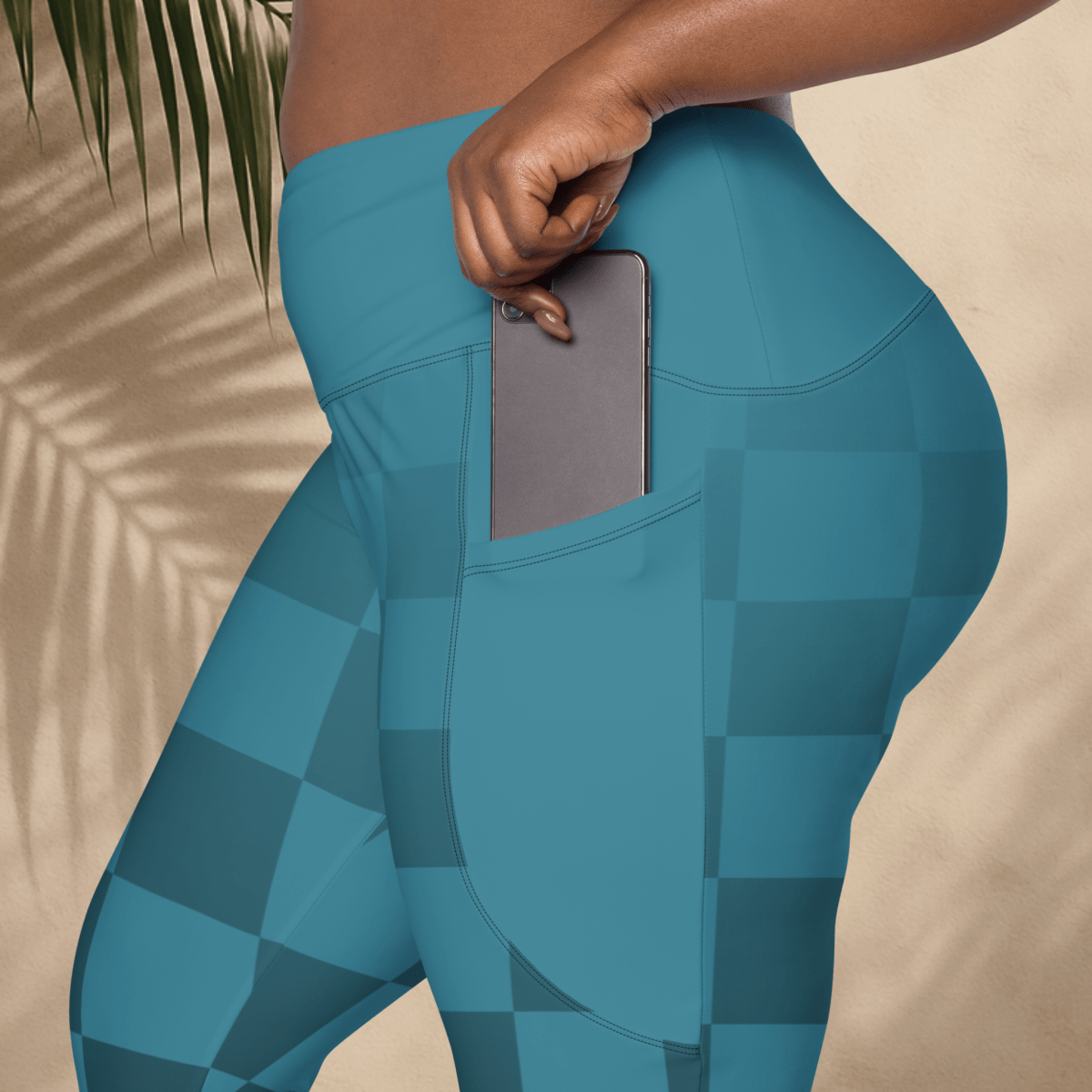 blue checkered leggings with a pocket holding a phone, against a neutral background.