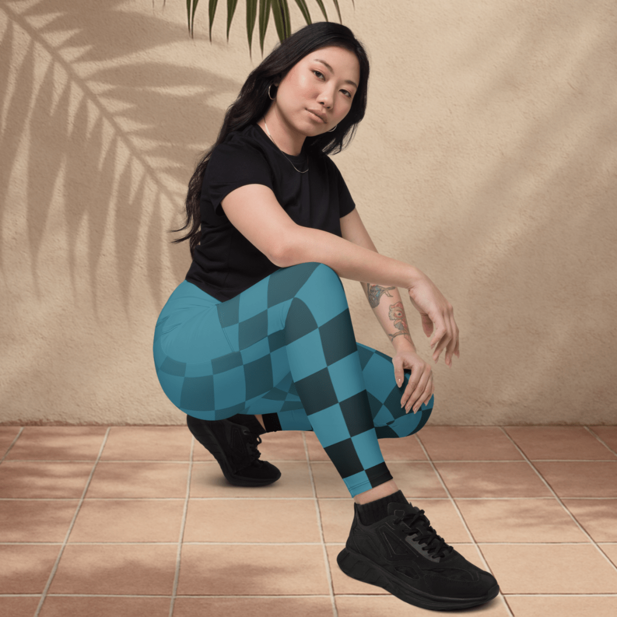 Person wearing blue and black checkered leggings sitting on a tiled floor.