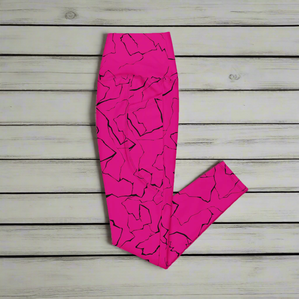 Pink leggings with black abstract pattern on a wooden surface