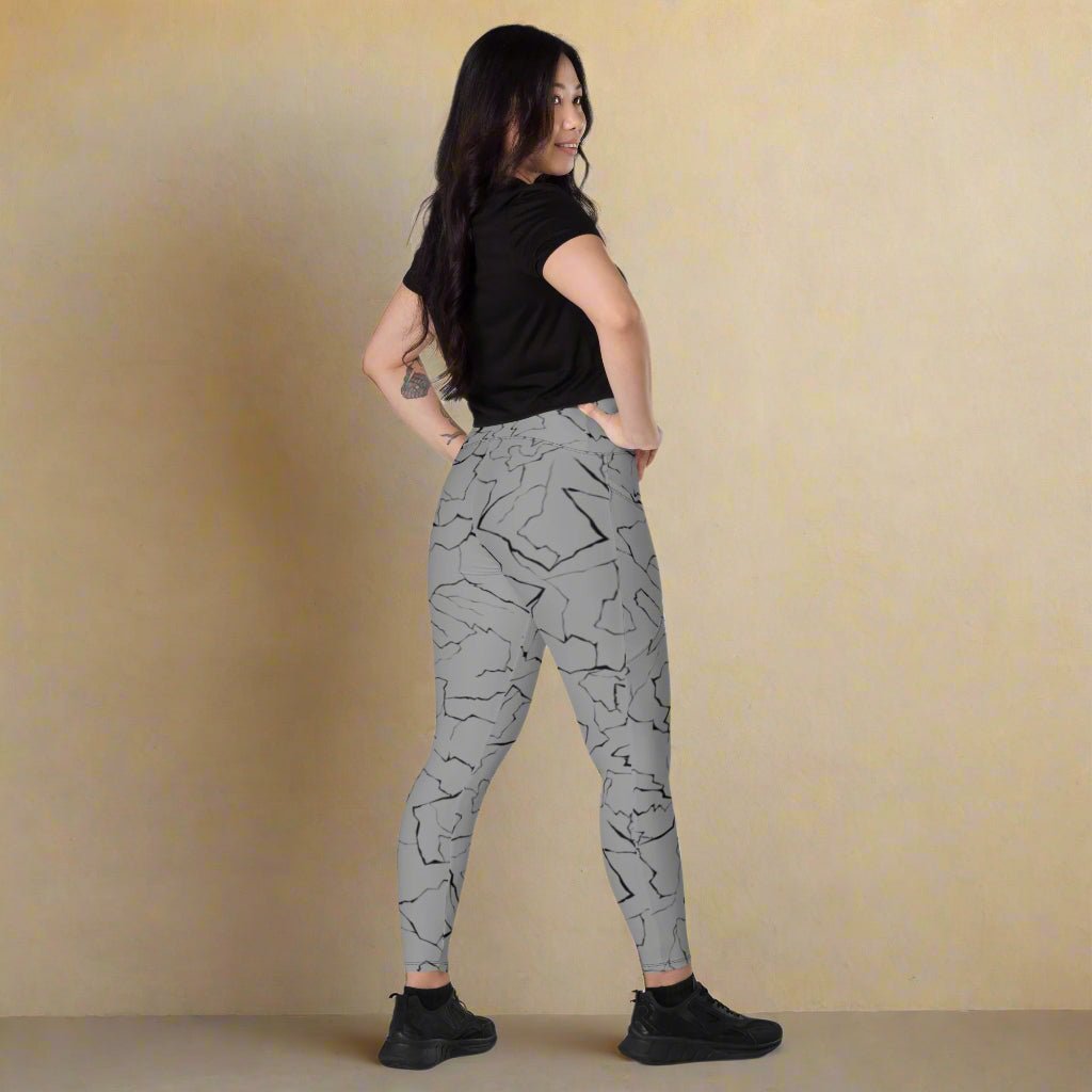 Person wearing gray patterned leggings on a beige background
