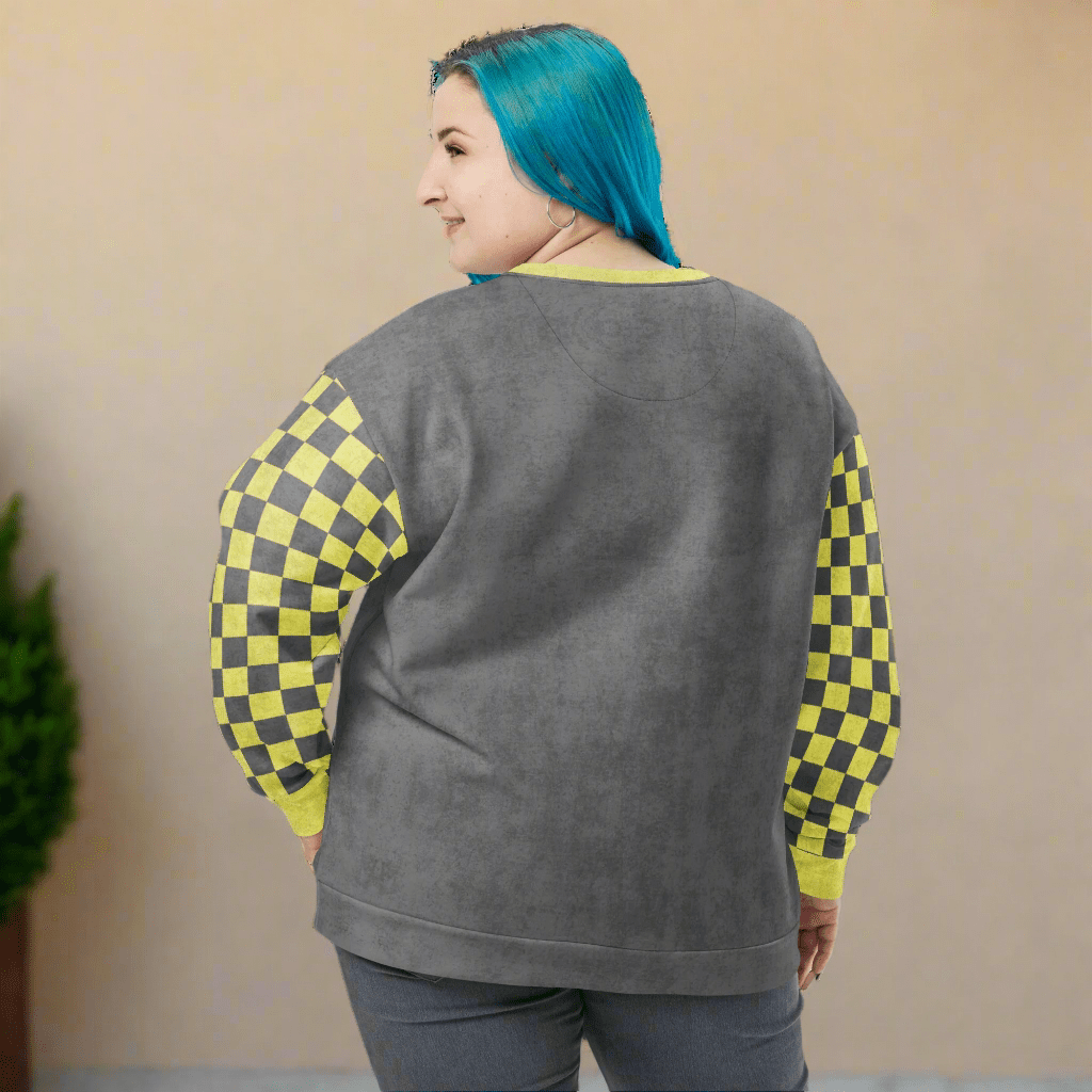 Person wearing a gray sweatshirt with checkered sleeves on a neutral background