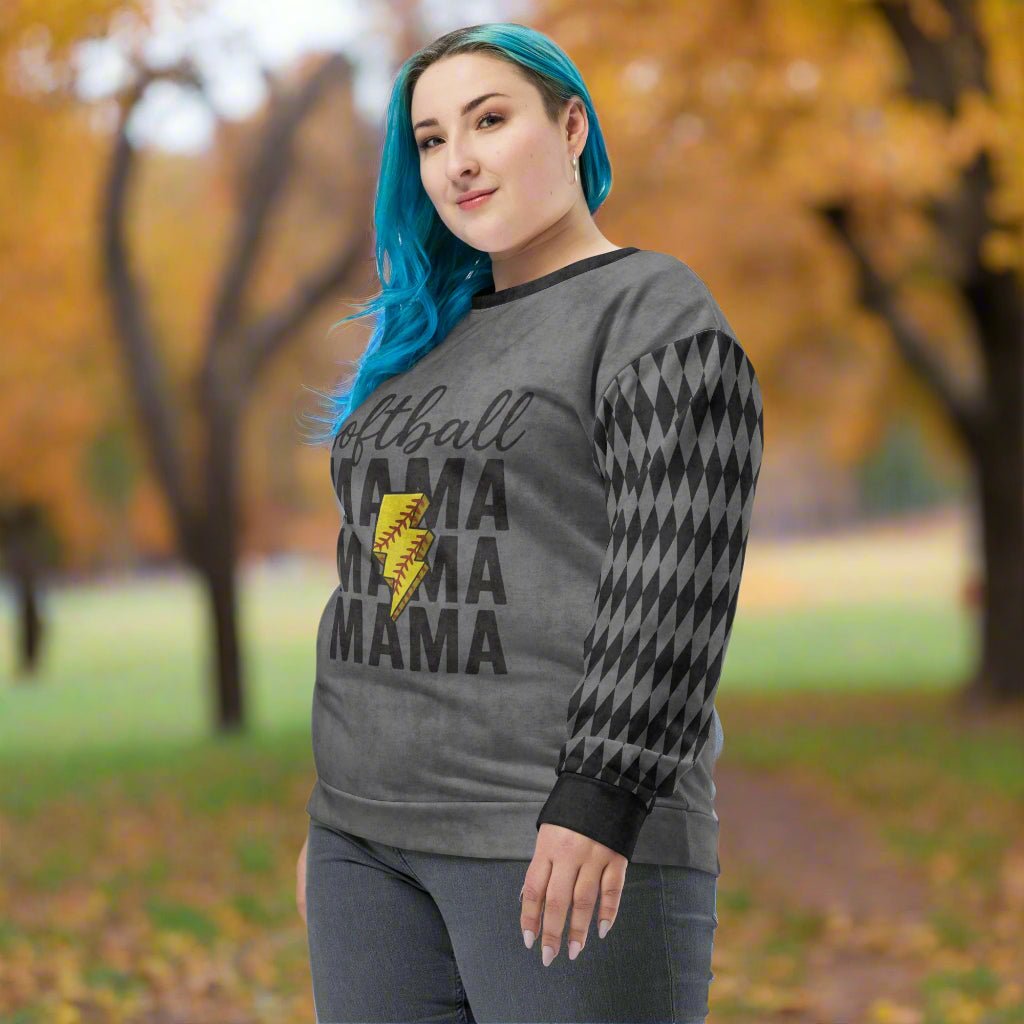 Woman wearing a gray sweatshirt with 'Softball Mama' text and lightning bolt graphic in an outdoor setting.