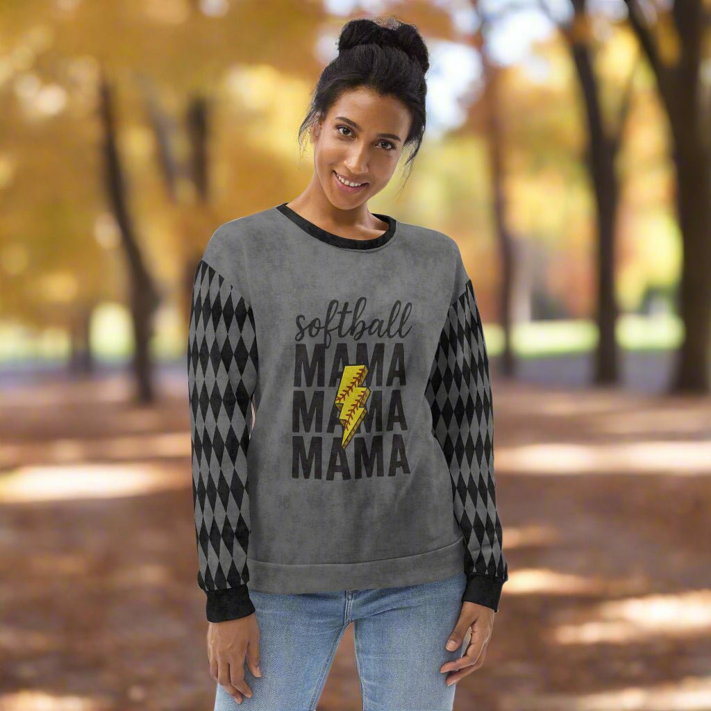 Woman wearing a gray sweatshirt with 'softball MAMA' text in an autumn setting