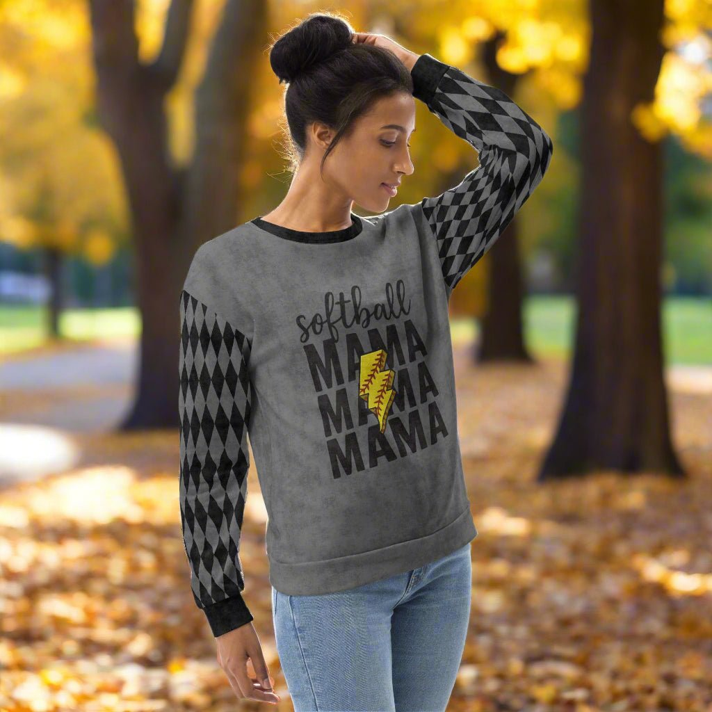 Woman wearing a gray sweatshirt with 'softball MAMA MAMA MAMA' text and checkered sleeves outdoors