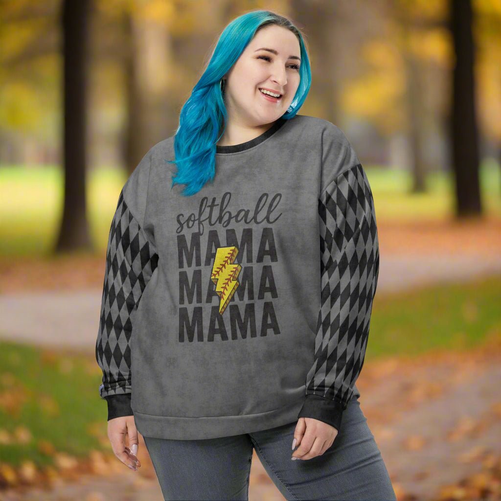 Person wearing a 'softball mama' sweatshirt in an outdoor setting with trees and grass.