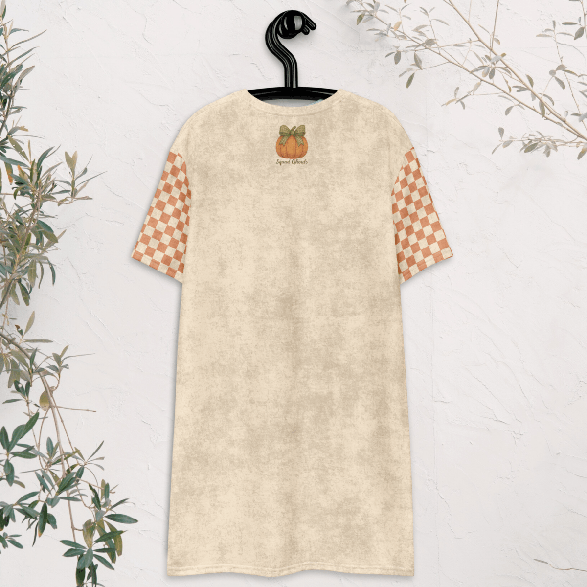 Beige dress with checkered sleeves on a hanger against a white background