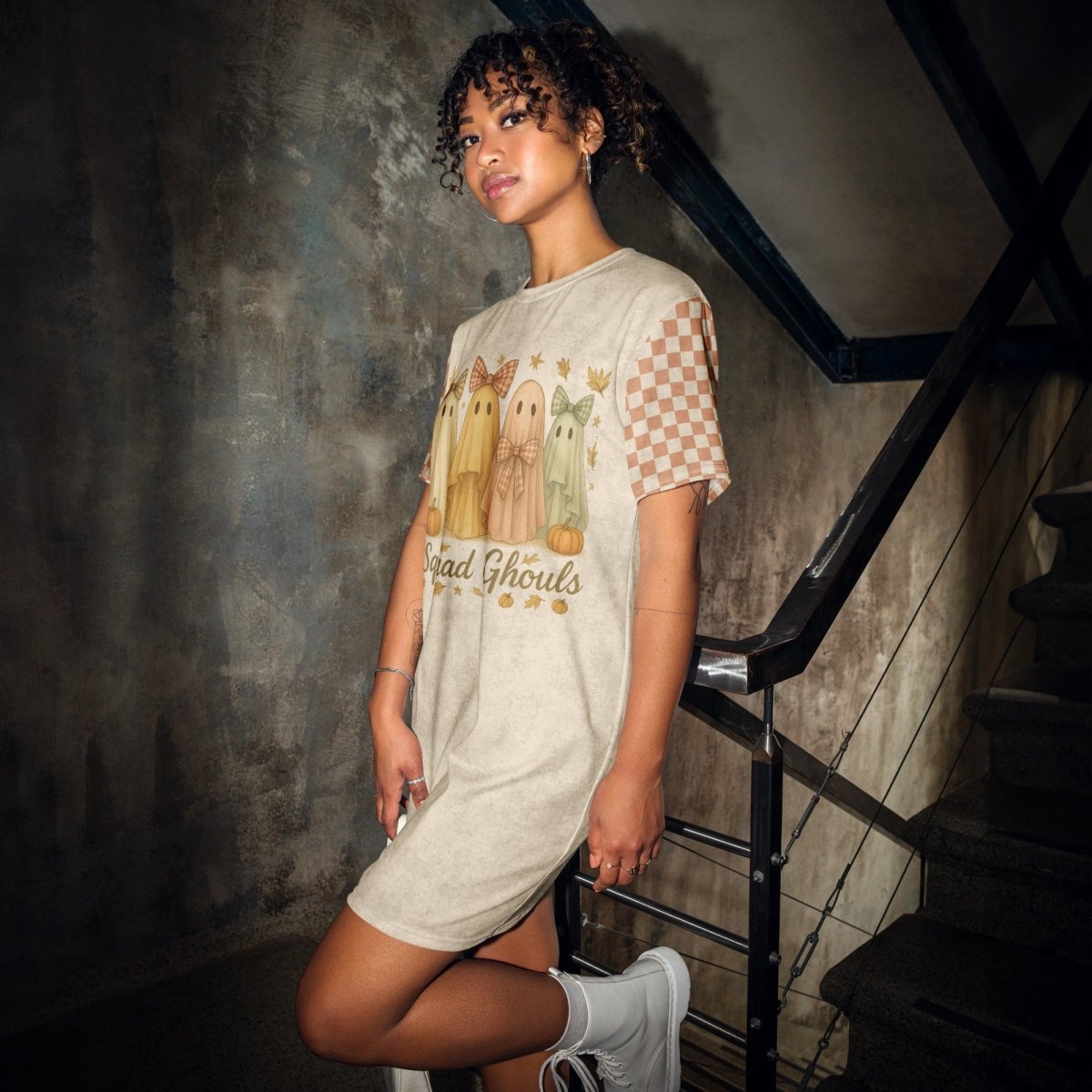 Woman wearing a graphic t-shirt dress in a dark indoor setting