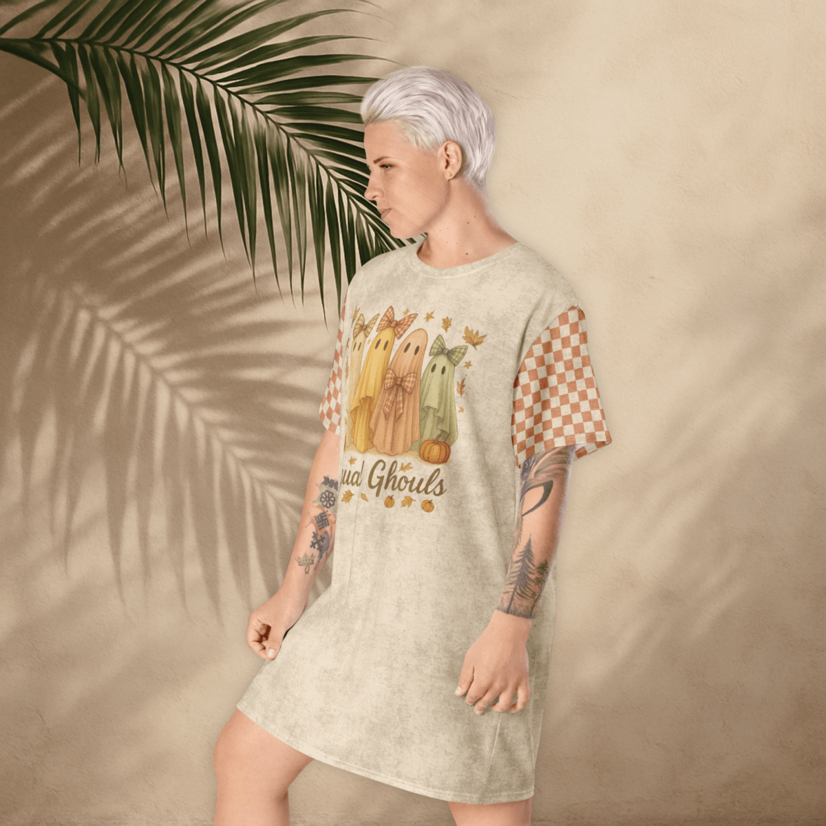 Person wearing a t-shirt dress with a graphic design against a beige background