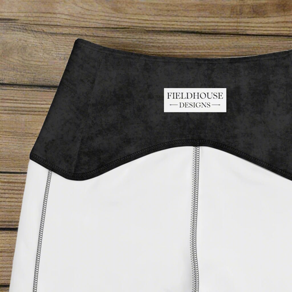 Close-up of a black waistband with 'Fieldhouse Designs' label on a wood background
