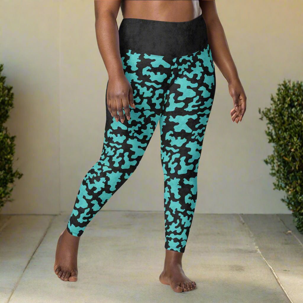 Teal and black camouflage leggings worn by a person on a neutral background