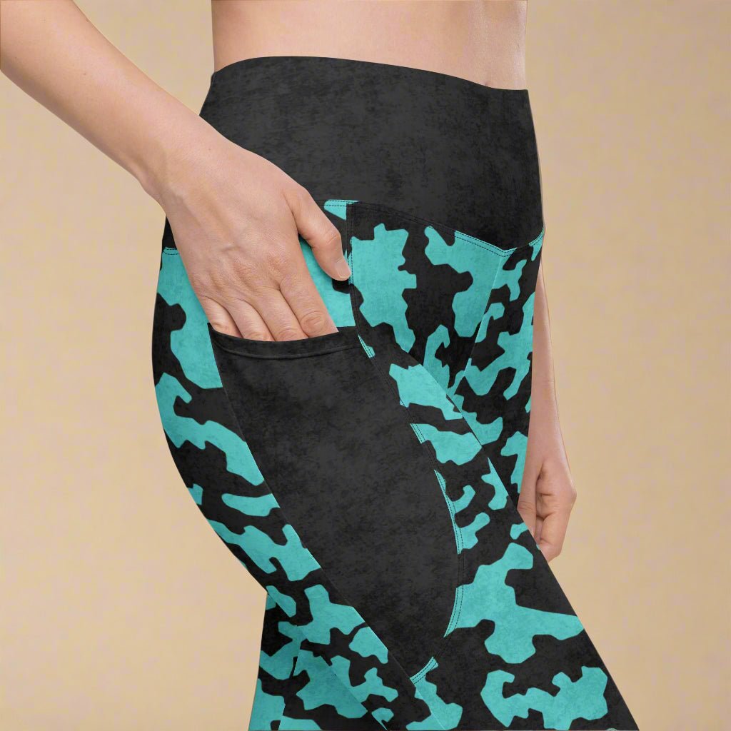 Black leggings with teal camouflage pattern worn by a person on a beige background